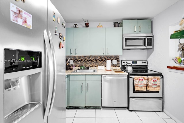 kitchen with stainless steel appliances, sink, light tile patterned floors, and backsplash