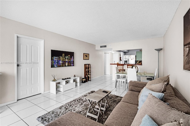 tiled living room featuring a textured ceiling