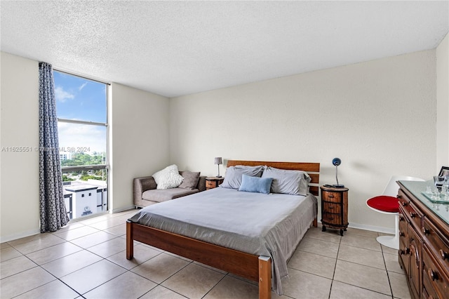 tiled bedroom featuring floor to ceiling windows and a textured ceiling