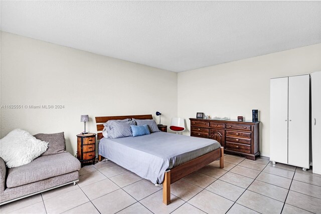 bedroom featuring light tile patterned flooring and a textured ceiling