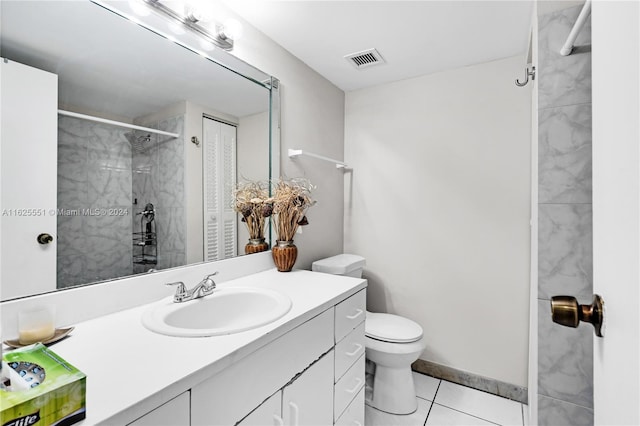 bathroom with vanity, a tile shower, tile patterned floors, and toilet