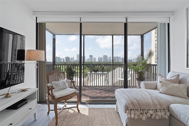 bedroom with multiple windows, a wall of windows, light hardwood / wood-style floors, and access to outside