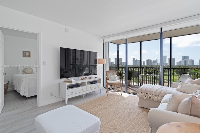 living room with hardwood / wood-style floors and a wall of windows