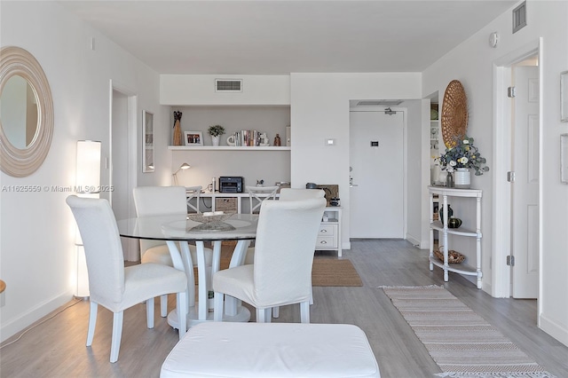 dining space with hardwood / wood-style flooring