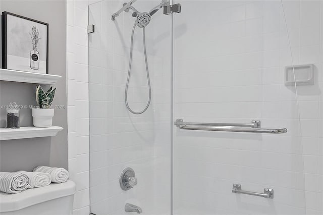 bathroom with tiled shower / bath combo and toilet