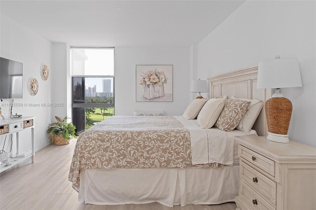 bedroom featuring floor to ceiling windows and light hardwood / wood-style flooring