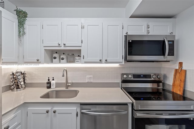 kitchen with white cabinetry, stainless steel appliances, sink, and tasteful backsplash