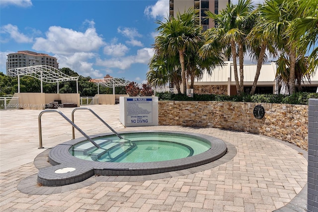 view of swimming pool with a hot tub and a patio