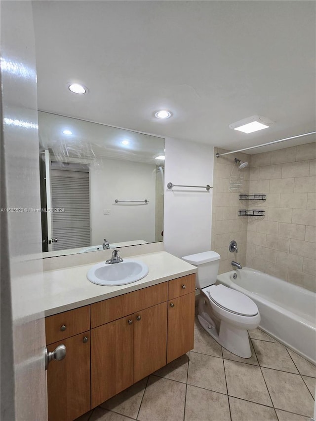 full bathroom featuring vanity, tiled shower / bath, toilet, and tile patterned floors