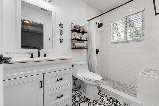 bathroom with tile patterned flooring, vanity, toilet, and curtained shower