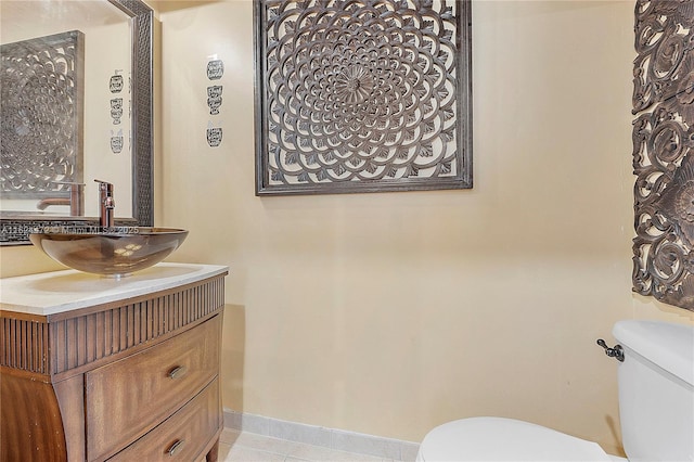 bathroom with toilet, tile patterned floors, and vanity