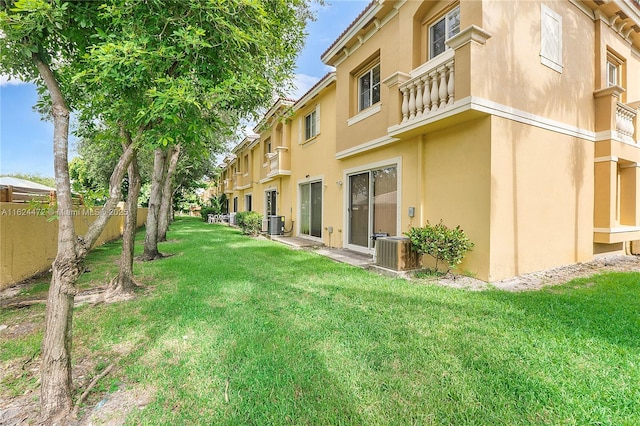 view of yard featuring central AC unit and a balcony