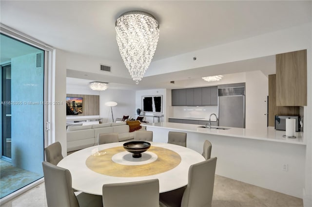 tiled dining space featuring sink and an inviting chandelier