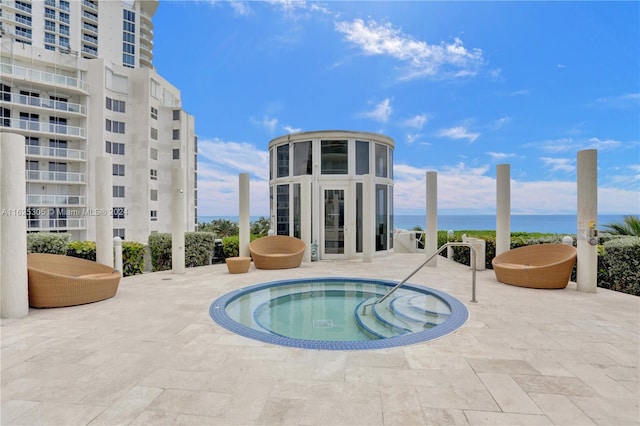 view of swimming pool featuring a water view, a hot tub, and french doors