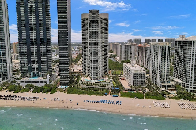 property's view of city featuring a water view and a beach view