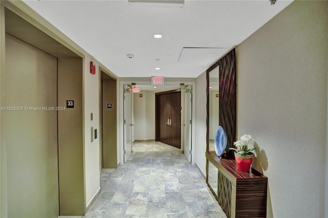 hall with elevator and light tile patterned floors