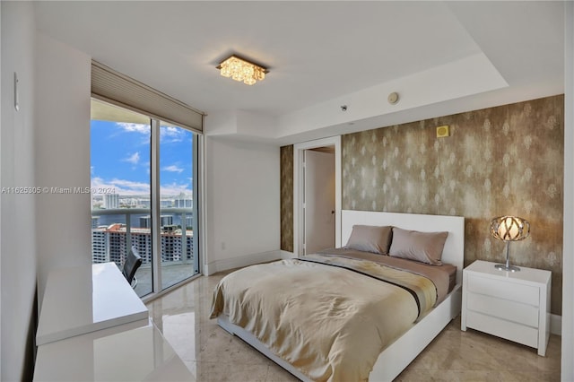 bedroom with light tile patterned flooring, a water view, access to exterior, and expansive windows