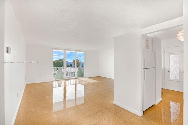 empty room with light tile patterned floors and a textured ceiling