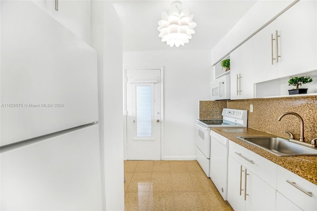 kitchen with light floors, white appliances, a sink, tasteful backsplash, and white cabinetry