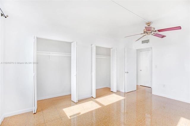 unfurnished bedroom with ceiling fan, baseboards, multiple closets, and visible vents