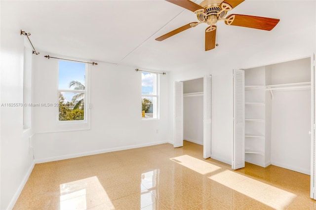 unfurnished bedroom featuring multiple closets, a ceiling fan, and baseboards