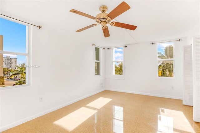 spare room with ceiling fan and baseboards