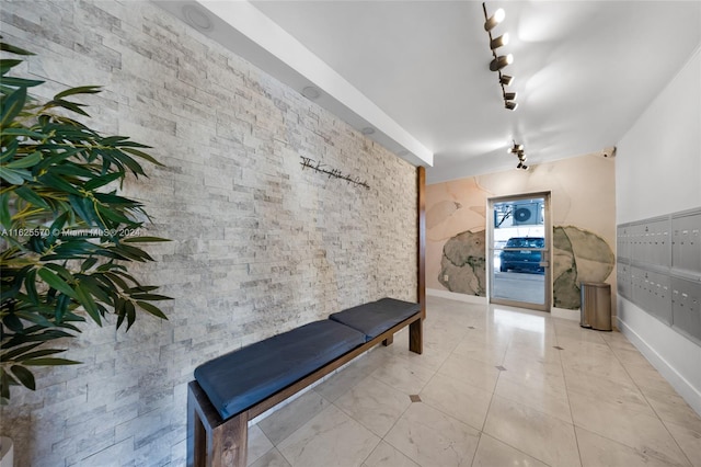 hall featuring rail lighting and light tile patterned floors