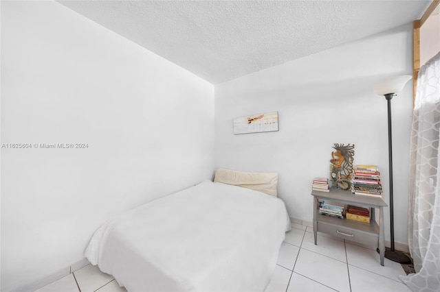 bedroom featuring a textured ceiling and light tile patterned floors