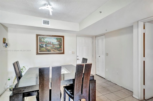 dining room with a textured ceiling and light tile patterned floors