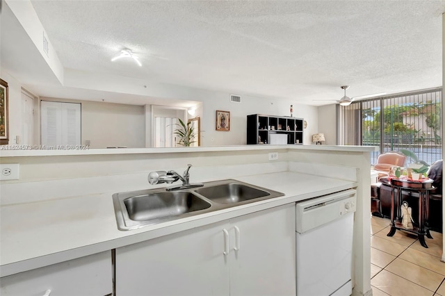 kitchen with light tile patterned flooring, white cabinets, white dishwasher, ceiling fan, and sink