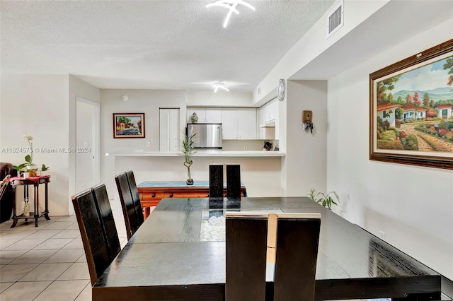 tiled dining room featuring a textured ceiling