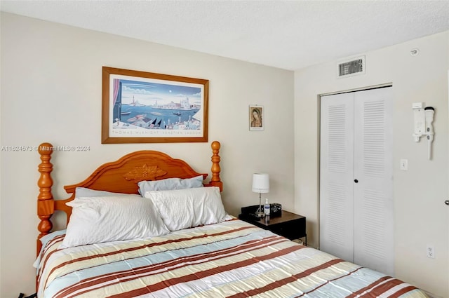 bedroom with a textured ceiling and a closet