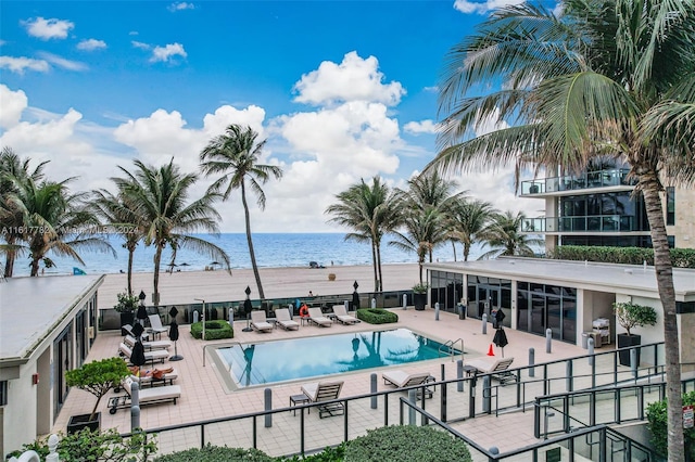 view of swimming pool featuring a water view and a patio