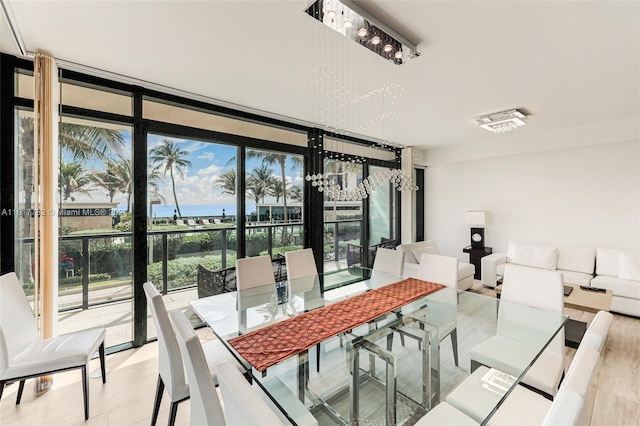 dining area featuring a water view, expansive windows, and a healthy amount of sunlight