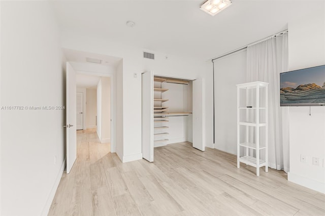 unfurnished bedroom with a closet and light hardwood / wood-style flooring