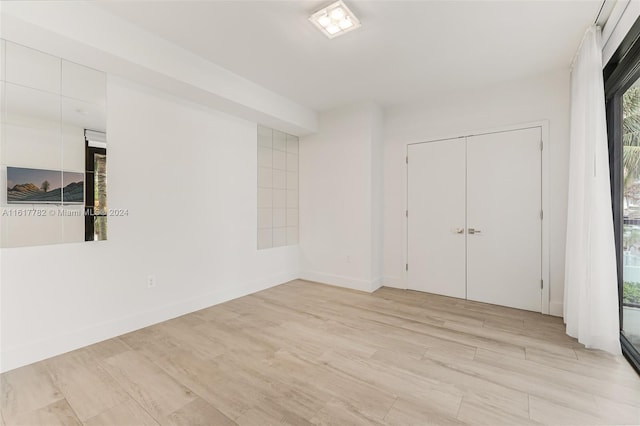 unfurnished bedroom with a closet and light hardwood / wood-style floors