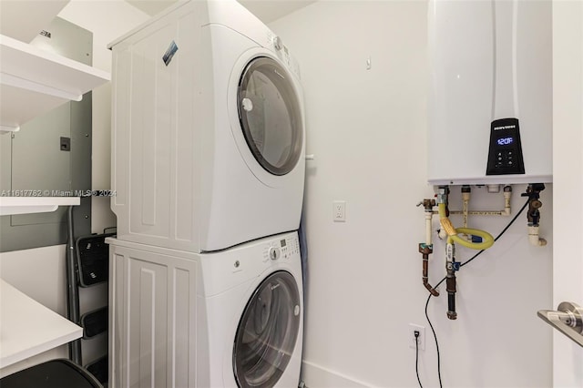 washroom with stacked washer / dryer and water heater