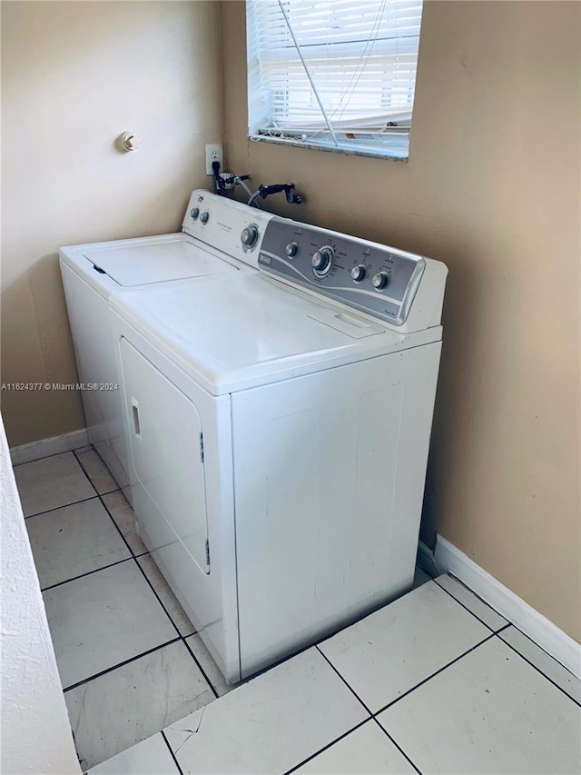 laundry room featuring separate washer and dryer and light tile patterned floors