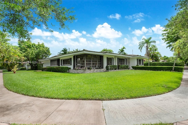 ranch-style home featuring a front lawn