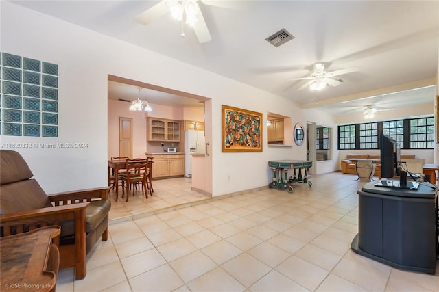 living room with ceiling fan with notable chandelier and light tile patterned floors