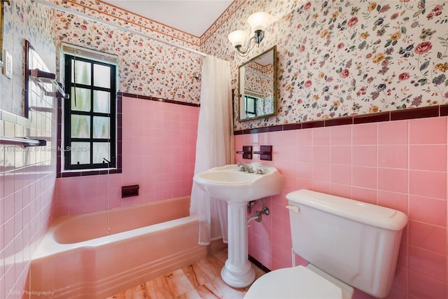 bathroom featuring toilet, shower / bath combo with shower curtain, and tile walls