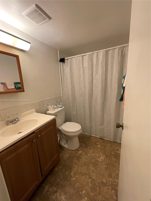 bathroom featuring tasteful backsplash, tile patterned floors, toilet, and vanity