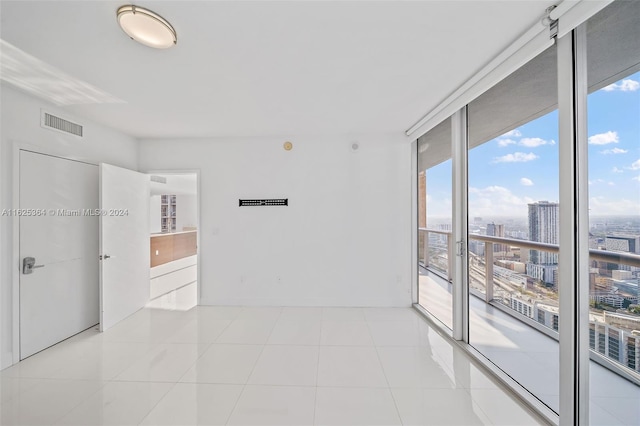 unfurnished room with floor to ceiling windows and light tile patterned floors