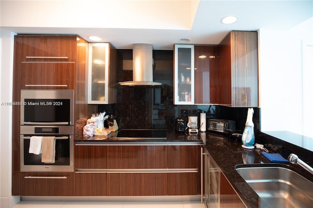 kitchen featuring sink, decorative backsplash, wall chimney exhaust hood, and light tile patterned floors