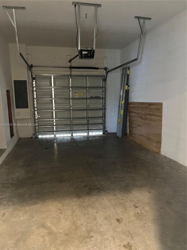 garage with gas water heater, a garage door opener, and electric panel