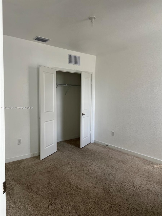 unfurnished bedroom with carpet floors and a closet