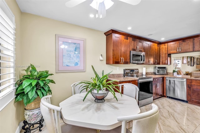 kitchen with ceiling fan, light stone countertops, and appliances with stainless steel finishes