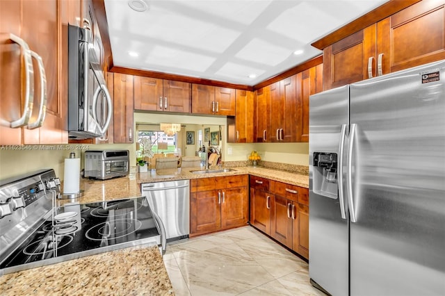 kitchen with light stone countertops, sink, and appliances with stainless steel finishes