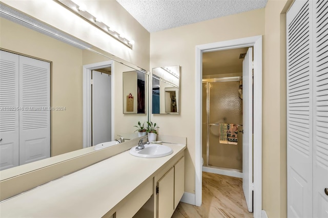 bathroom featuring vanity, a textured ceiling, toilet, and an enclosed shower