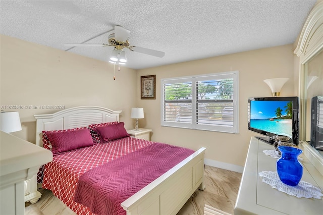 bedroom featuring ceiling fan and a textured ceiling